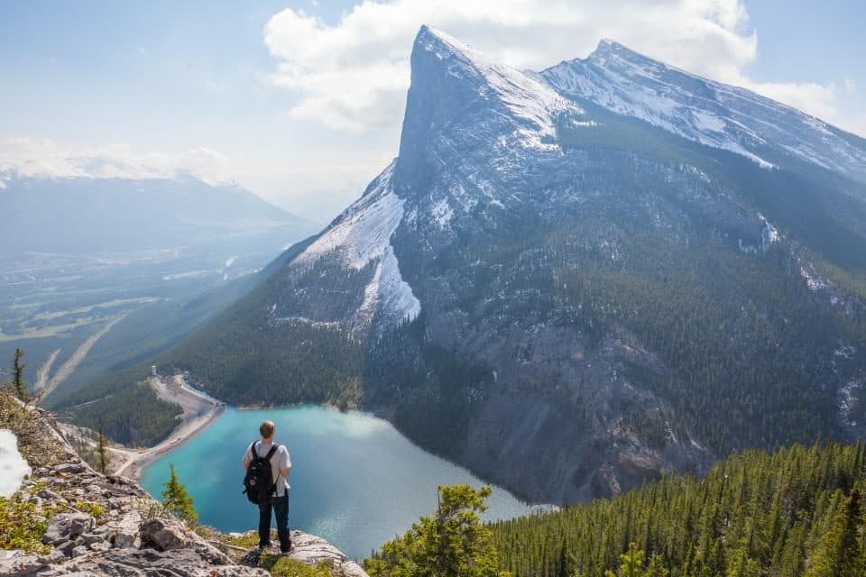 Person standing before a mountain landscape